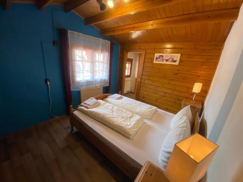 a bedroom with a bed in a wooden room at Gasthaus Goa in Ernsthausen