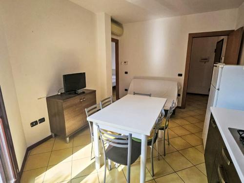 a kitchen with a white table and a refrigerator at Apartment Mairen-3 by Interhome in Rosolina Mare