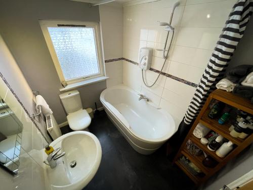 a bathroom with a sink and a tub and a toilet at Stags View in Invergarry