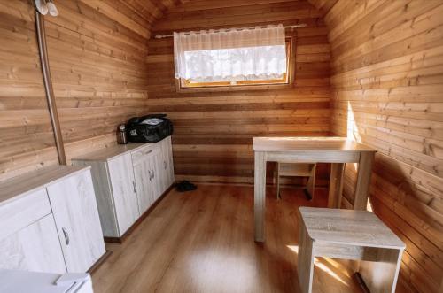 a room with two tables and a window in a log cabin at Schlaffass direkt am See in Heideblick