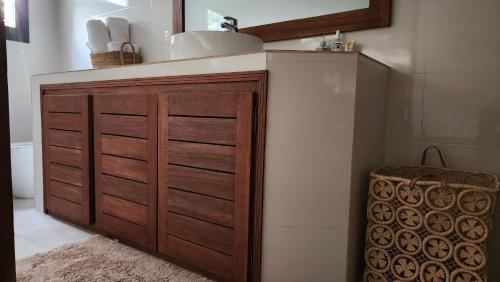 a bathroom with a wooden cabinet with a counter top at Suñu Tool Private Farm Guesthouse in Sindia