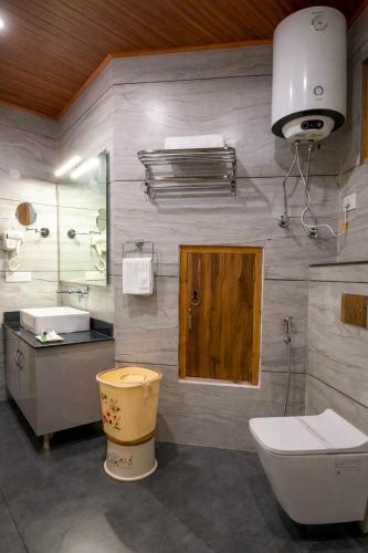a bathroom with a toilet and a sink at Regal Retreat Inn in Shirir