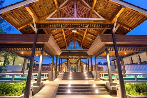 a large wooden pavilion with stairs and a pool at OUTRIGGER Khao Lak Beach Resort in Khao Lak