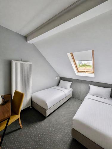 ein Zimmer mit zwei Betten, einem Schreibtisch und einem Fenster in der Unterkunft Casa Boca- free parking in Cluj-Napoca