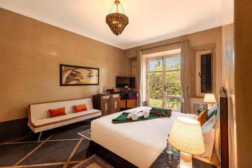 a bedroom with a bed and a chair and a window at Janat Al Atlas Resort & Spa in Marrakesh