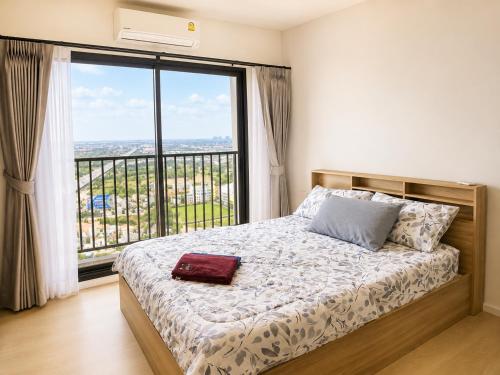 a bedroom with a bed with a large window at Lucky 98 Sky Stay in Bang Phli