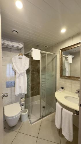 a bathroom with a shower and a toilet and a sink at Sunrise Resort Hotel in Kizilagac