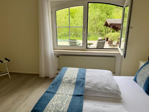 a bedroom with a bed and a large window at Moseloase am Weinberg mit Pool und Sauna in Bullay in Alf