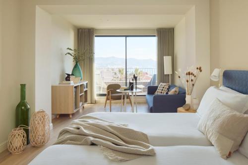a bedroom with a bed and a living room at ME by Meliá Sitges Terramar in Sitges