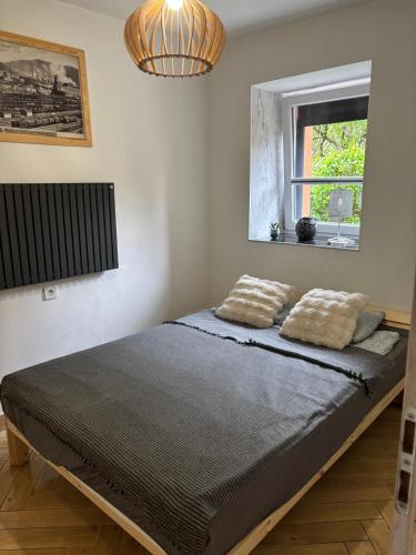 a bedroom with a bed with two pillows on it at Apartament Traugutta duży in Wałbrzych