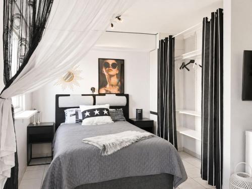 a bedroom with a black and white bed with curtains at Apartment Brömsebro by Interhome in Halmstad