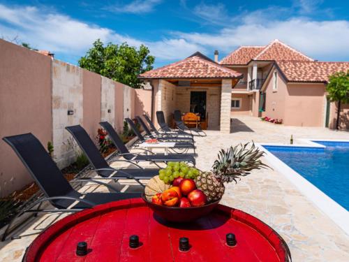 a bowl of fruit on a table next to a pool at Holiday Home Šimić by Interhome in Dušić