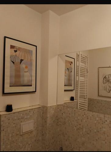 a bathroom with a mirror and a tiled wall at Dimora Victoria in Ascoli Piceno