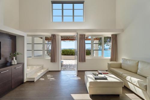 a living room with a couch and a tv at Hydra Beach Resort in Thermisía