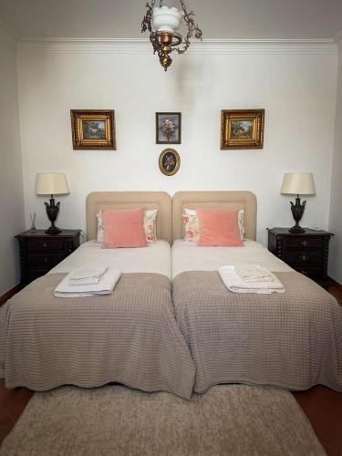 a bedroom with two beds with pink pillows at Villa Reis - Boutique House in Golegã
