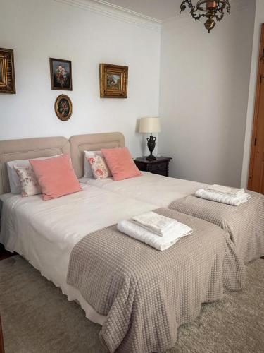 a bedroom with two beds with pink pillows at Villa Reis - Boutique House in Golegã