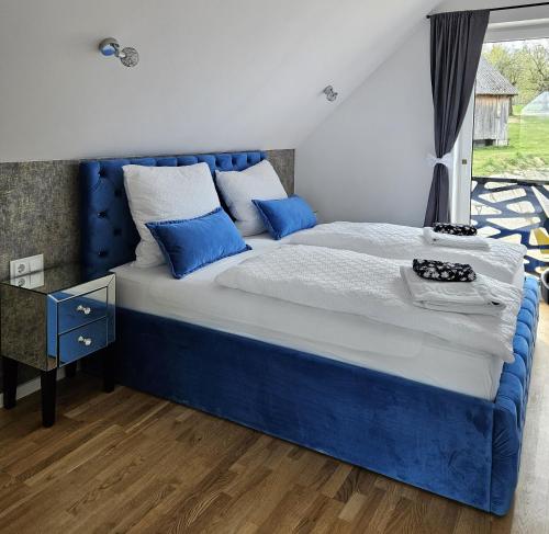 a bedroom with a blue bed and a window at Królowa Beskidu in Słopnice