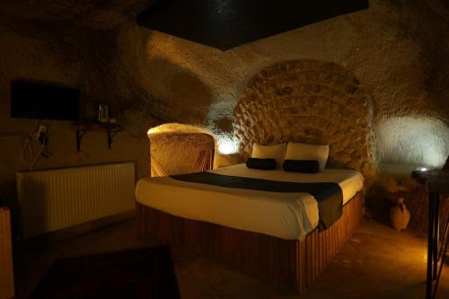a bedroom with a bed in a stone room at Rock Mansion Cappadocia in Nar