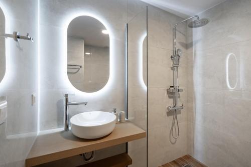 a bathroom with a sink and a shower at Faflagos Apartments in Psari Forada