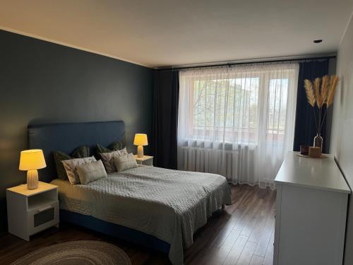 a bedroom with a bed and a large window at Karusselli beach home, free parking in Pärnu