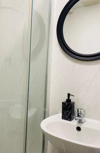 a bathroom with a sink and a mirror at Lovely studio centrally located in Peterborough