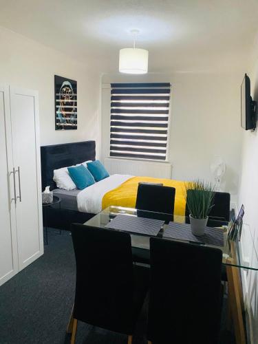 a bedroom with a bed and a desk with a table at Lovely studio centrally located in Peterborough