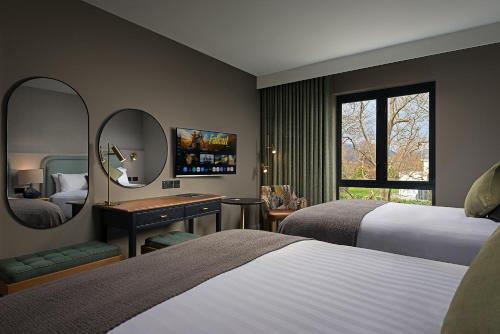 a hotel room with two beds and a mirror at The Parkavon Hotel in Killarney