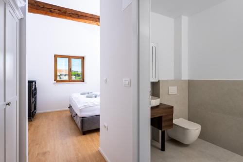 a bathroom with a sink and a toilet and a bed at Villa Sofija in Vodnjan