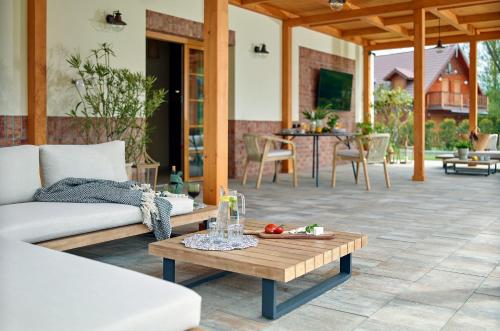 a patio with a couch and a coffee table at Lipowa Przystań in Tarnów Jezierny