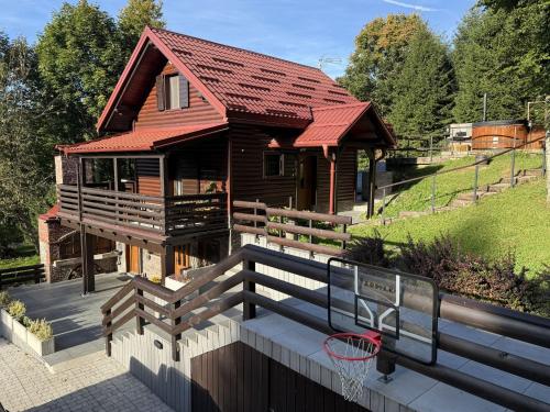 a house with a basketball hoop in front of it at Chalet Cozy Bear Cabin by Interhome in Mrkopalj
