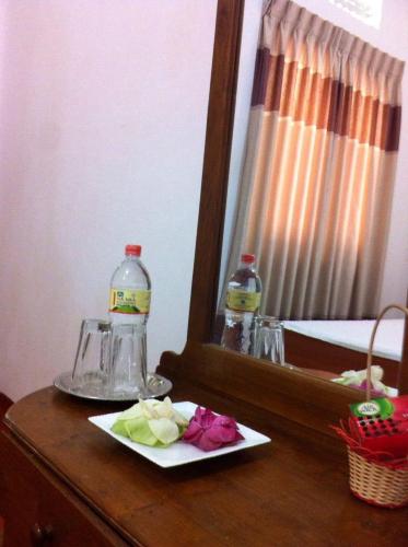 a table with a mirror and a plate with flowers at Mahaweli Shades in Kandy