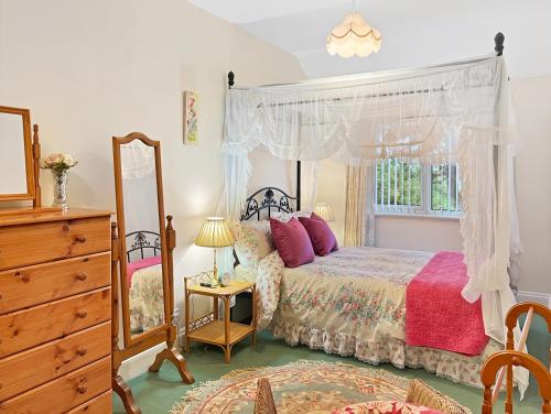 a bedroom with a bed and a dresser and a mirror at Exmoor View Wootton Courtenay in Minehead