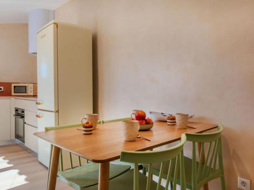 a kitchen with a wooden table and green chairs at Apartment Edificio Candela-2 by Interhome in L'Ametlla de Mar
