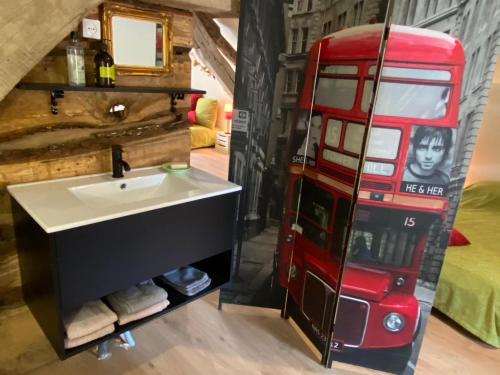 a bathroom with a red double decker bus at Gite Simon in Guillon