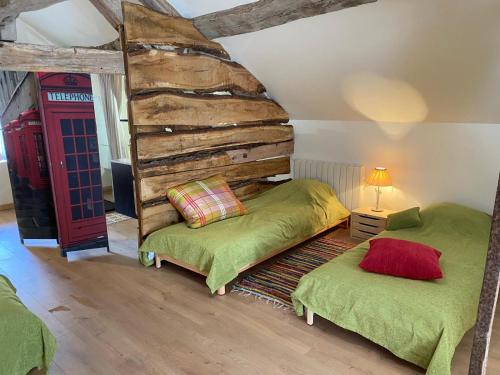 a bedroom with two beds and a red telephone booth at Gite Simon in Guillon