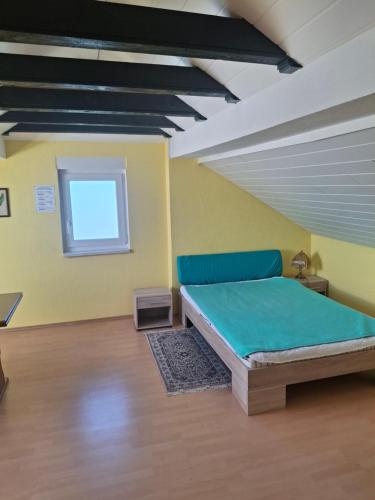 a bedroom with a bed in a room with a window at Haus Tanja in Neckarbischofsheim