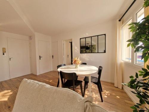 a dining room with a white table and chairs at Liv'in Saint Seb, proche de Nantes in Saint-Sébastien-sur-Loire