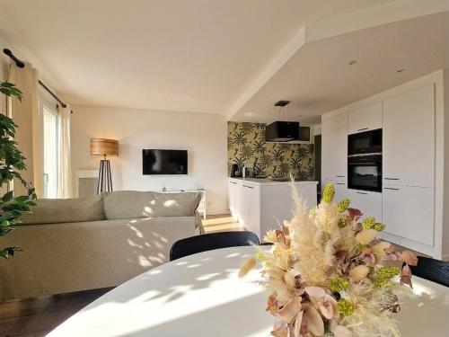 a living room with a couch and a table at Liv'in Saint Seb, proche de Nantes in Saint-Sébastien-sur-Loire