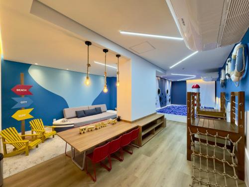 a living room with a couch and a table at Apartamento em Condomínio Frente-Mar com Piscinas, Jacuzzi Aquecida, Sauna, Academia, Brinquedoteca, Churrasqueira na Sacada, Cozinha Completa in Piçarras
