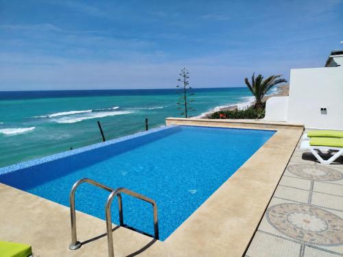a swimming pool with a view of the ocean at Maison Bella View in Moulay Bousselham