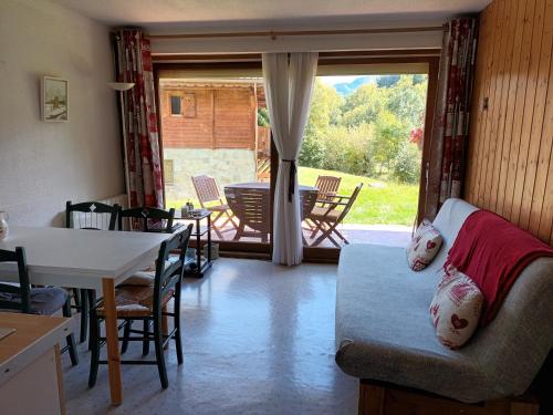 a living room with a couch and a table and chairs at Le Bochate in La Celle-sous-Gouzon