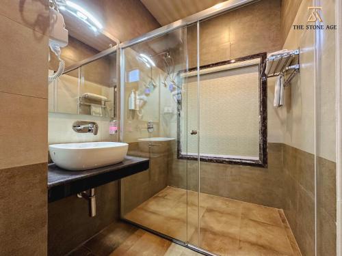 a bathroom with a sink and a glass shower at The Stone Age : a boutique hotel in Shimla