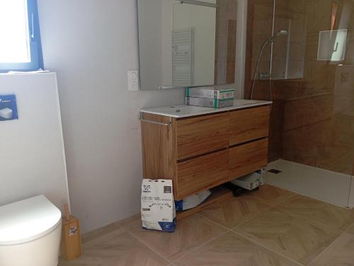 a bathroom with a wooden dresser and a toilet at maison wave in Léon