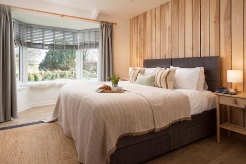 a bedroom with a large bed and a window at Border View Cottage in Duddo