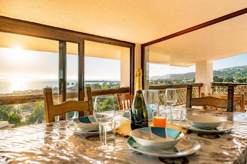 a table with glasses and a bottle of wine on it at ALBA - Seaview Luxury in San Teodoro