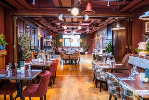 a restaurant with wooden floors and tables and chairs at The Royal Foresters, Ascot, Berkshire - Acorn Pubs in Ascot