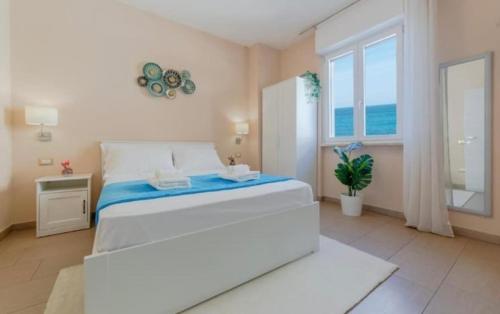a white bedroom with a large bed and a window at RossoCorallo in Gallipoli