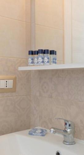 a bathroom with a sink and a shelf with cups at RossoCorallo in Gallipoli