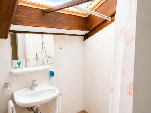 a bathroom with a sink and a mirror at Parkhotel Emmaus - Casa Rustico in Ascona