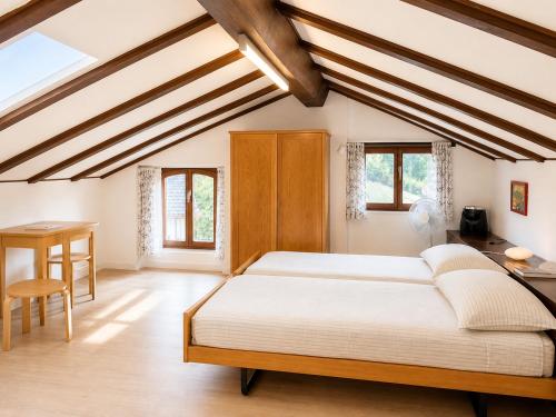 a bedroom with a bed and a desk and windows at Parkhotel Emmaus - Casa Rustico in Ascona